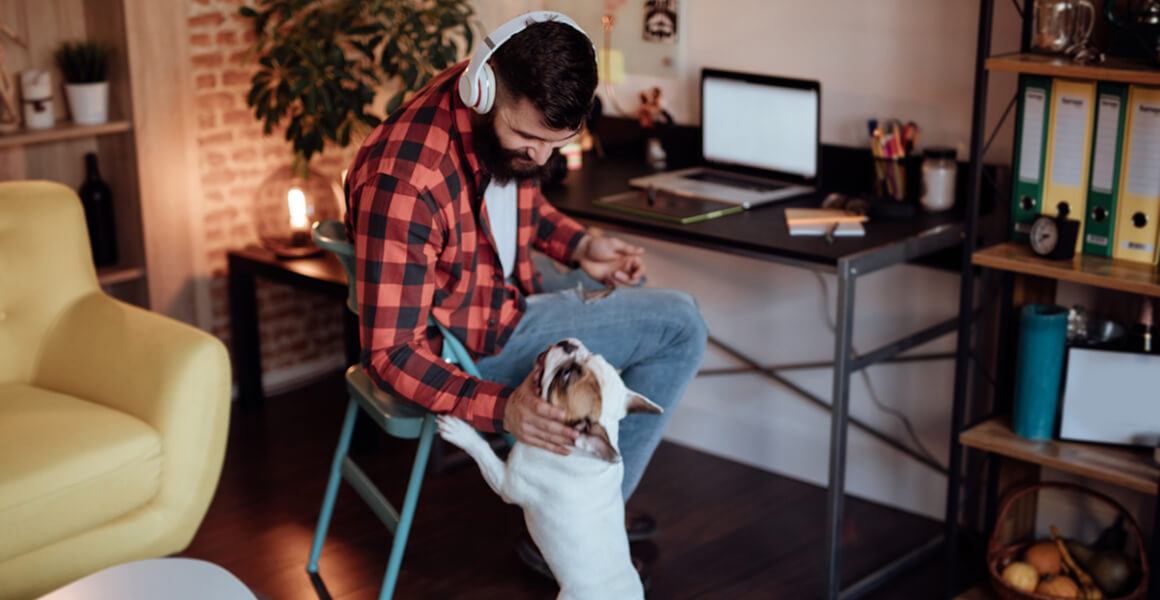 https://blog.tryshiftcdn.com/uploads/2020/03/man-working-from-home-with-dog-1.jpg